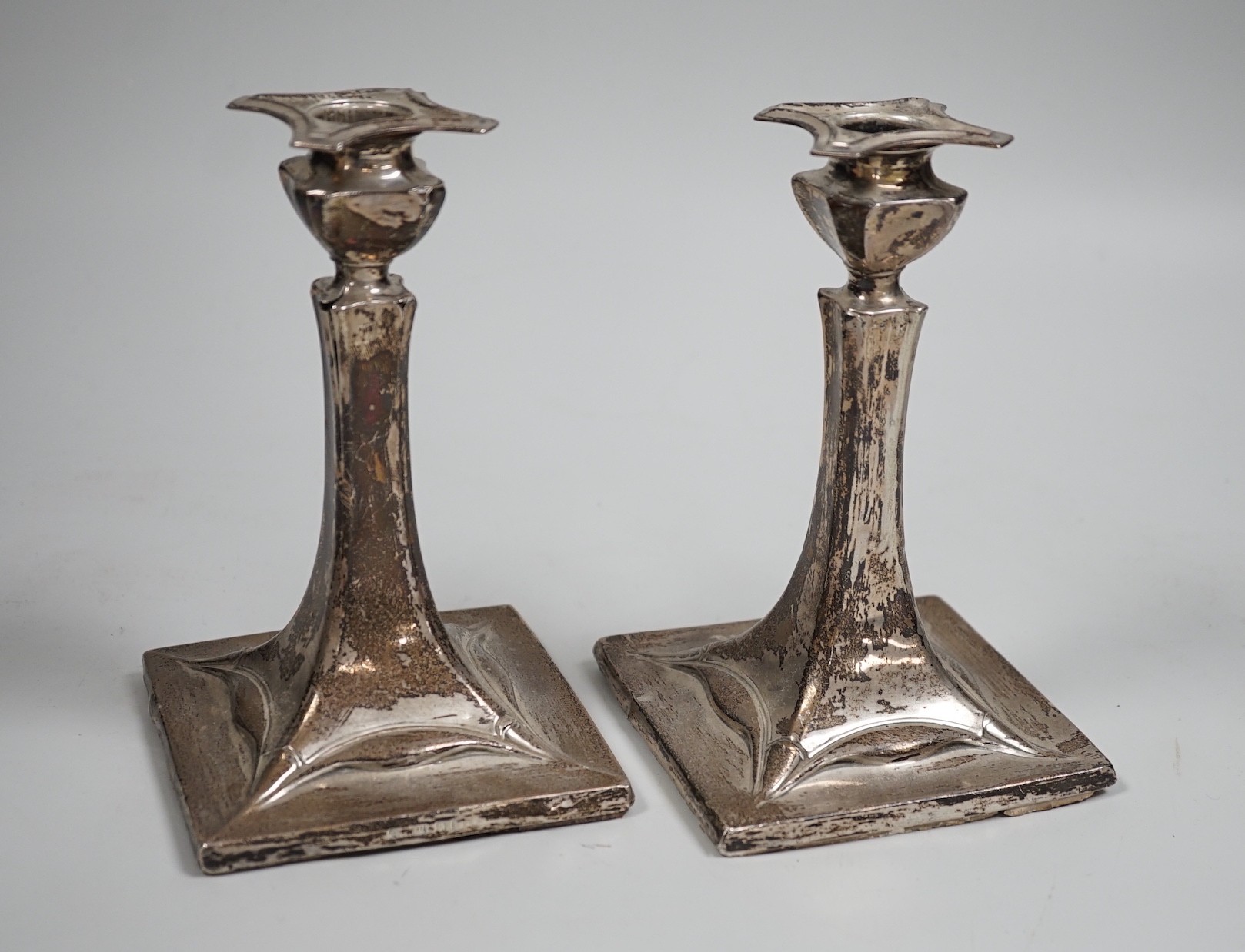 A pair of early 20th century Art Nouveau silver mounted candlesticks, marks rubbed (a.f.), height 15.2cm.